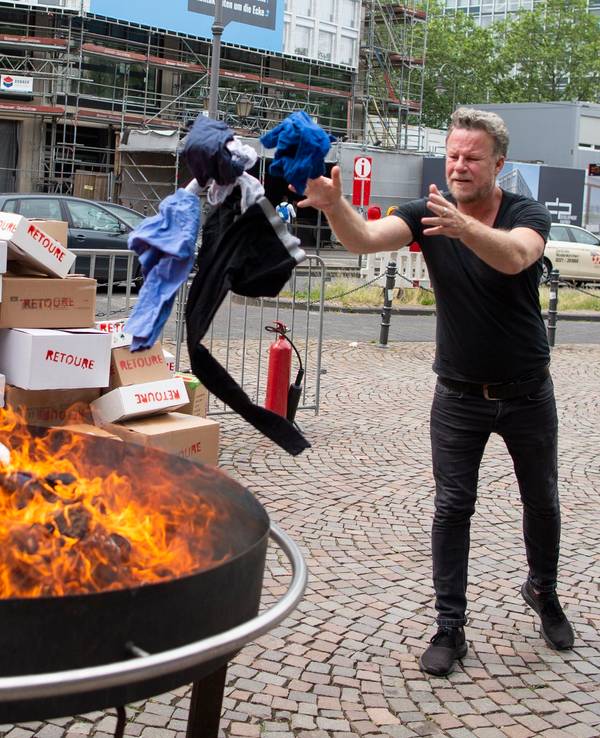 Jenke von Wilmsdorff wirft Klamotten in ein Feuer in Köln. Foto von der dpa, honorarfrei