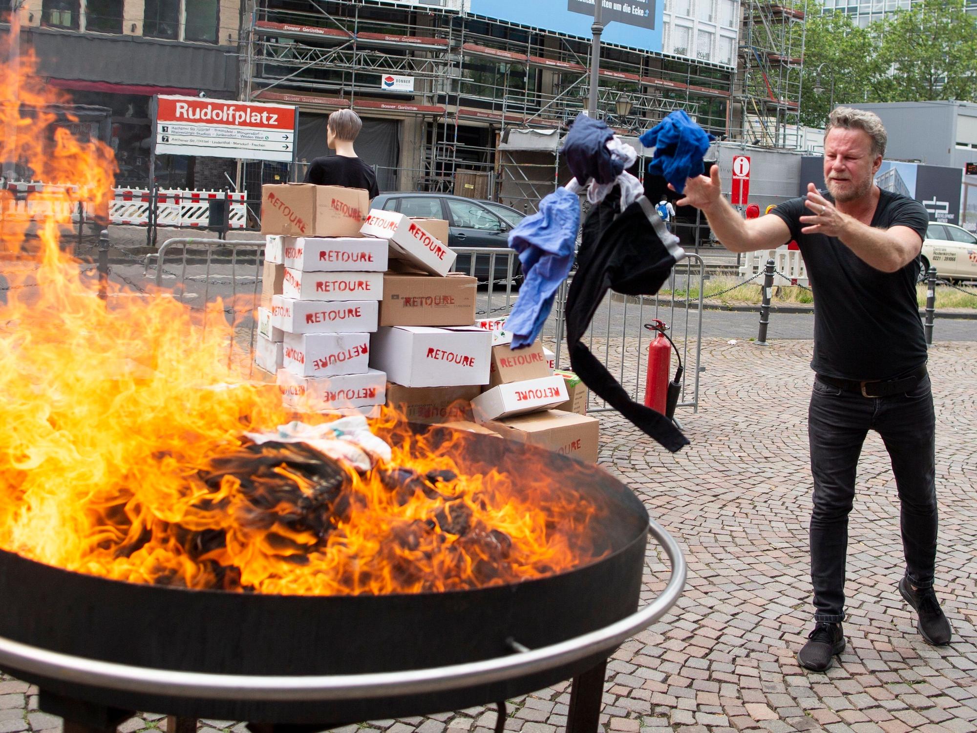 Jenke von Wilmsdorff wirft Klamotten in ein Feuer in Köln. Foto von der dpa, honorarfrei
