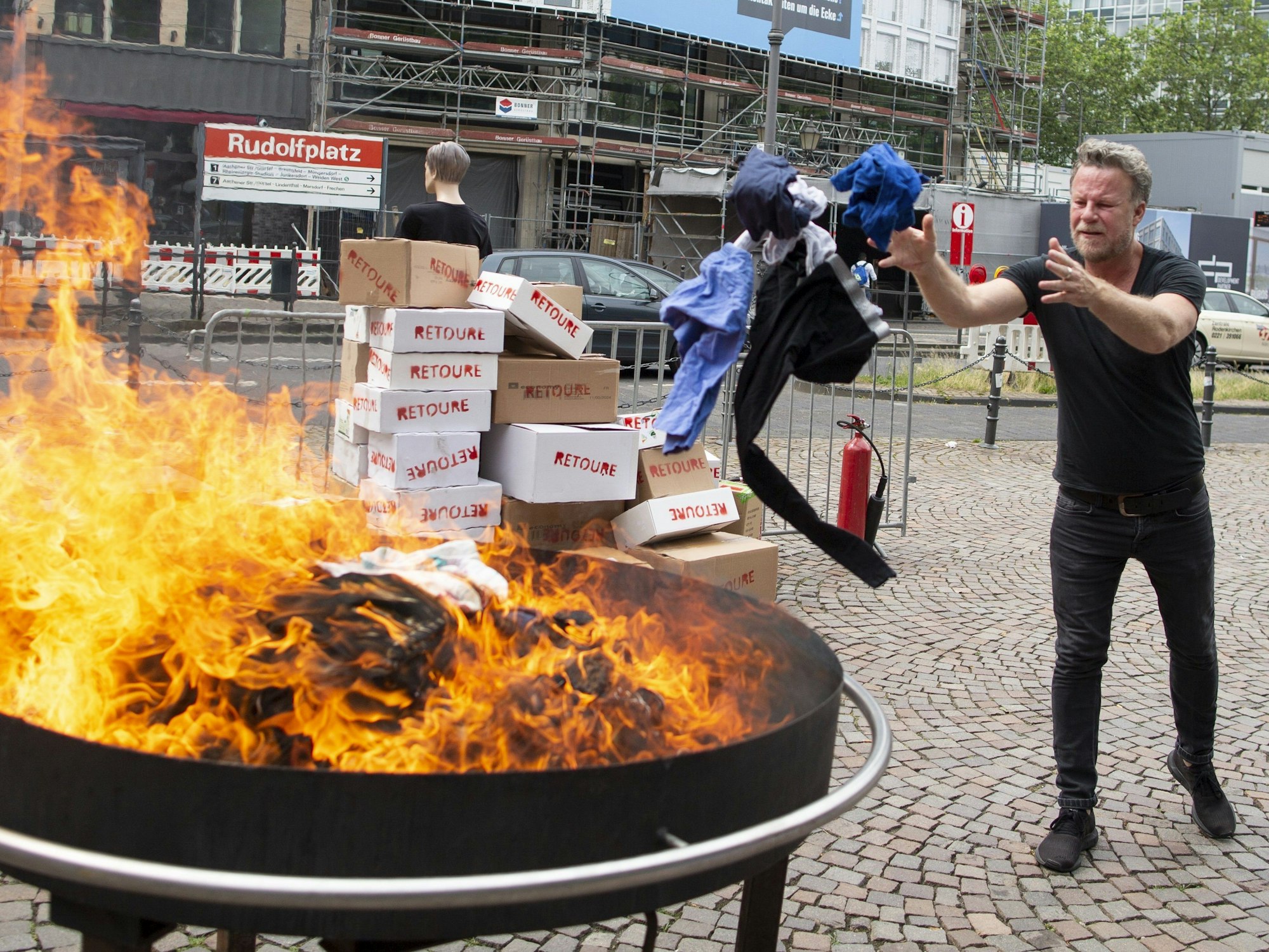 Jenke von Wilmsdorff wirft Klamotten in ein Feuer in Köln. Foto von der dpa, honorarfrei