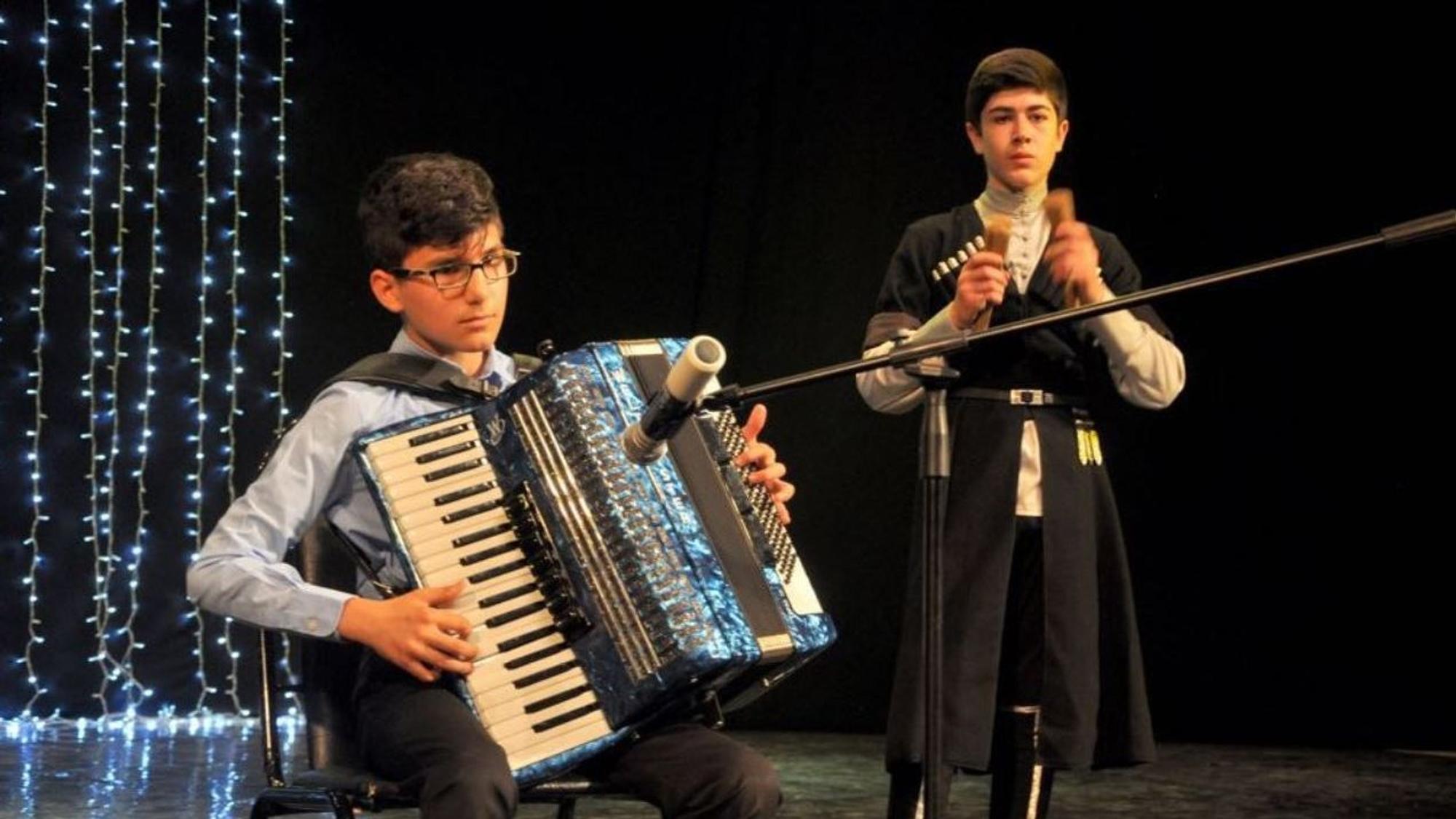 Der Kölner Akkordeonist Mert Aksoylu (15) spielt auf der Bühne ein Lied bei eiem Auftritt 2019 in Russland.