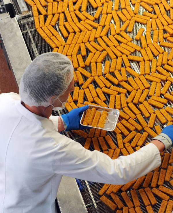 Ein Mitarbeiter kontrolliert Fischstäbchen bei Frosta. Die Verbraucherzentrale hat Produkte untersucht, die auf Fisch verzichten.