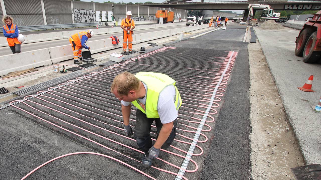 Ein Arbeiter bringt auf einem Testgelände neben der A3 Rohrleitungssysteme an.