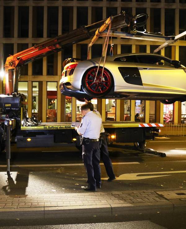 Unter den Augen der Kölner Polizei wird ein Sportwagen auf den Abschlepper geladen.