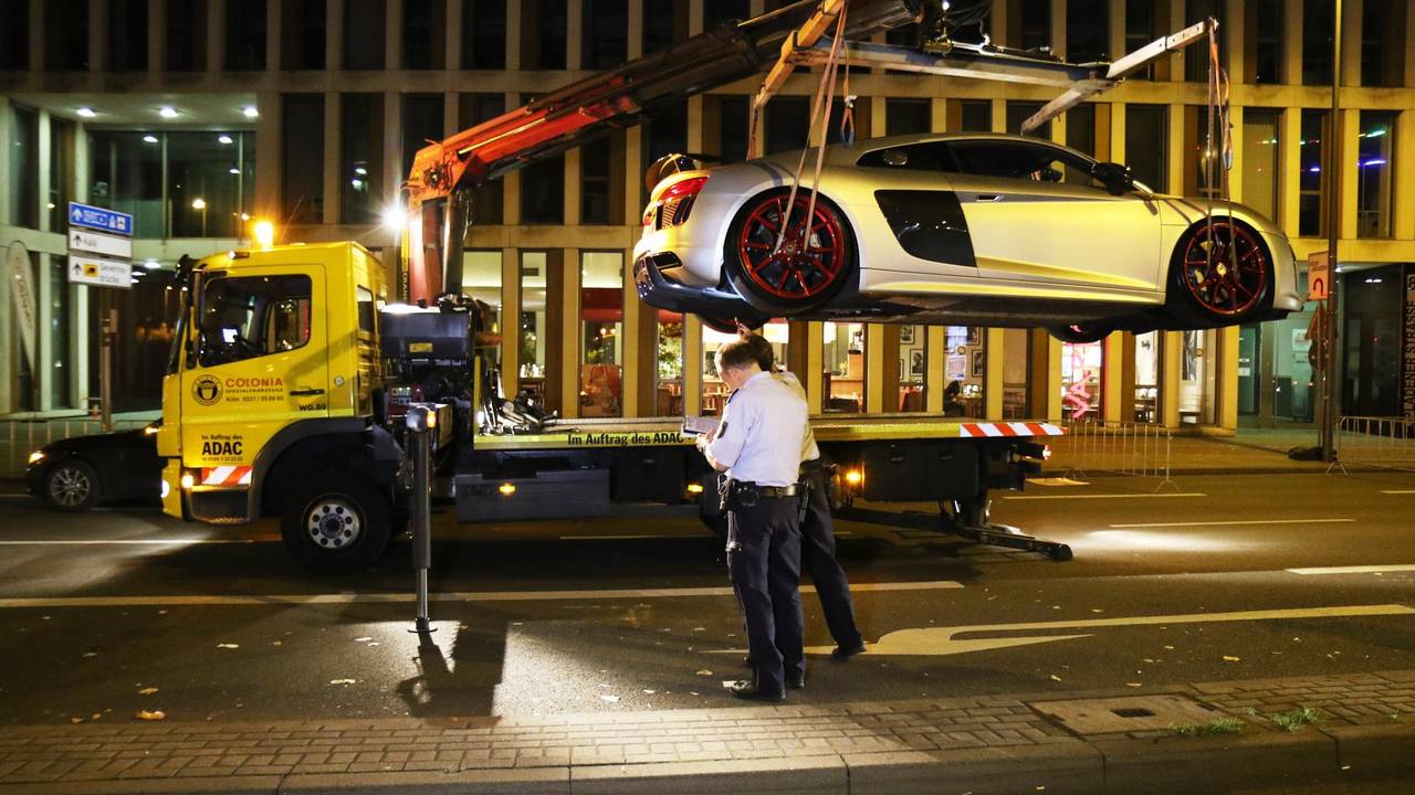 Unter den Augen der Kölner Polizei wird ein Sportwagen auf den Abschlepper geladen.