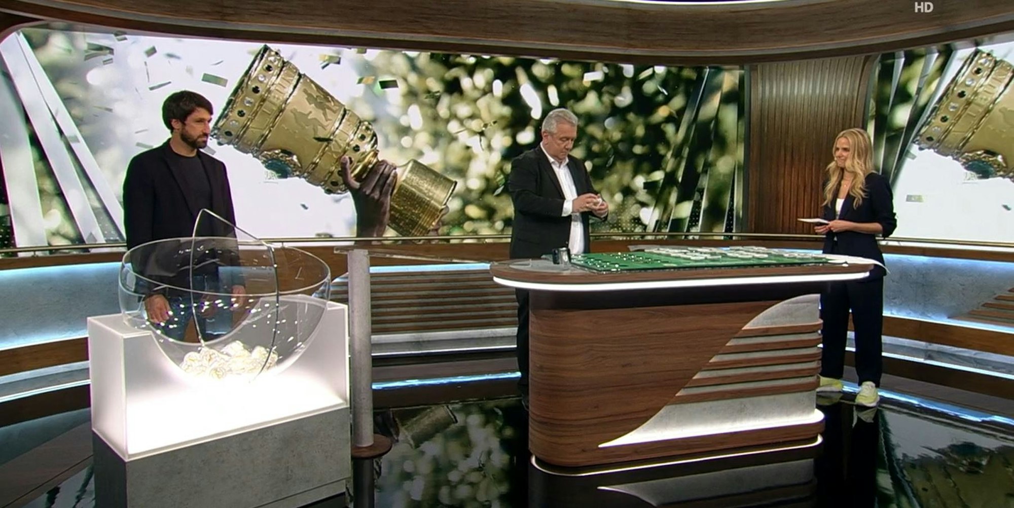Ex-Profi Thomas Broich lost in der ARD-„Sportschau“ die erste Runde des DFB-Pokals aus. Rechts Moderatorin Stephanie Müller-Spirra, in der Mitte DFB-Vize Peter Frymuth.