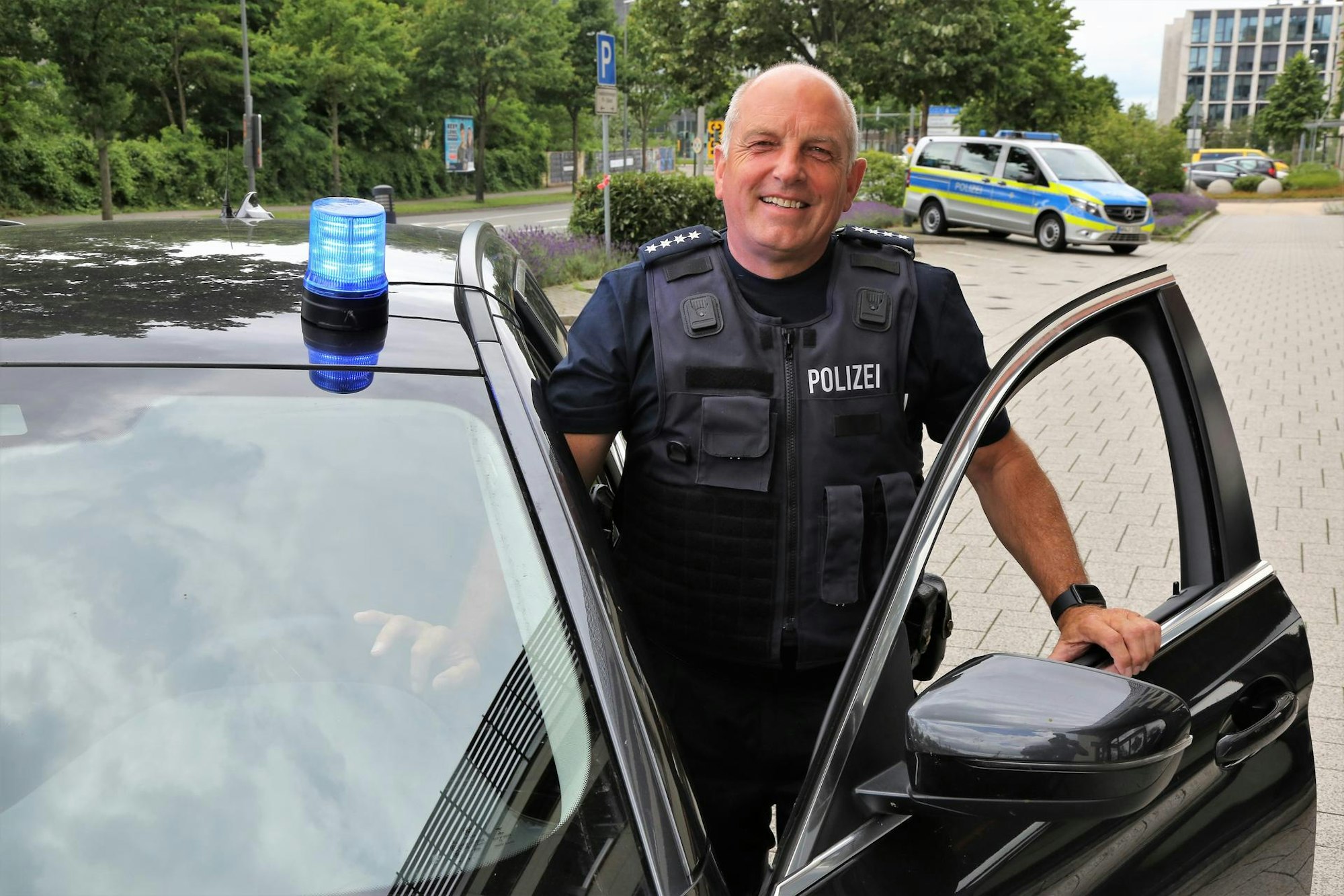Jürgen Berg (59), Leiter der Einsatzgruppe Verkehr der Kölner Polizei, steht an seinem Einsatzwagen.