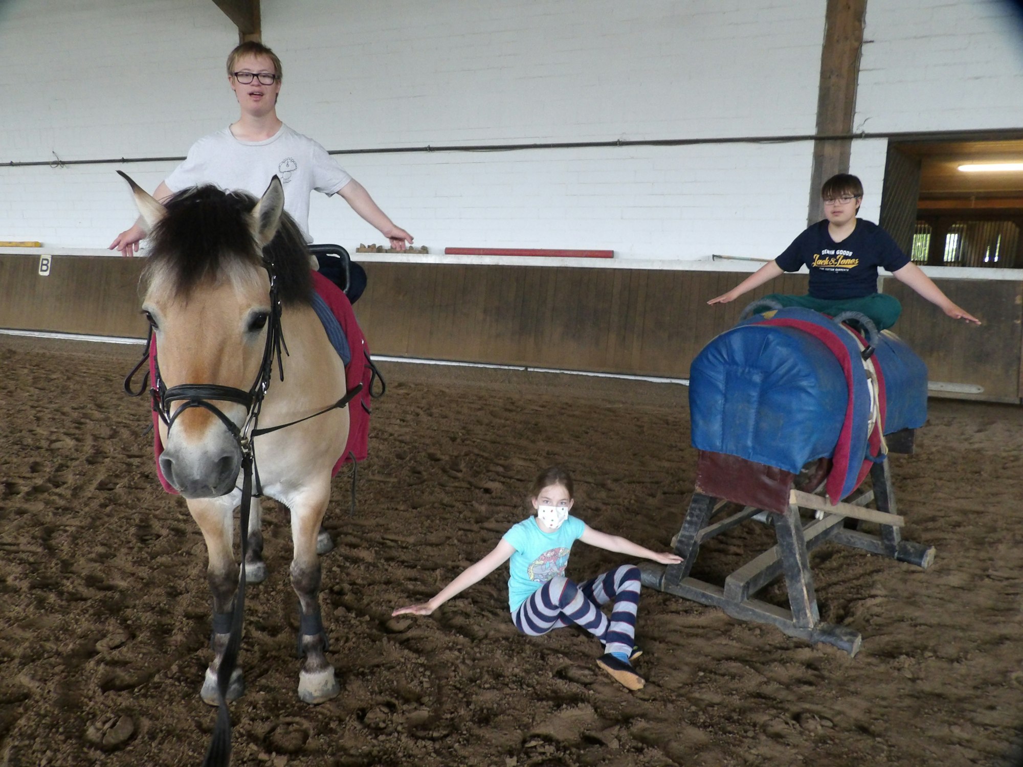 Kinder mit einem Therapiepferd während der Reittherapie.