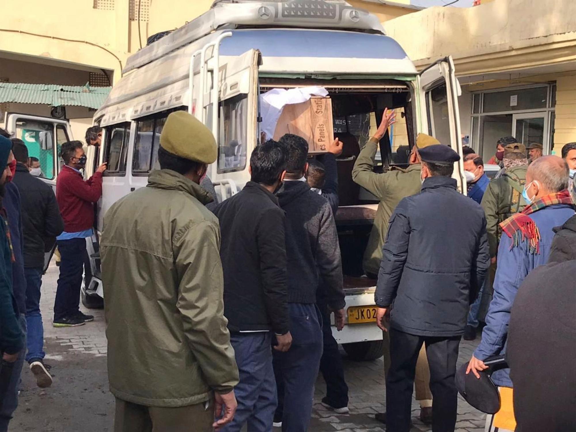 Polizisten helfen beim Verladen des Sarges eines Opfers einer Massenpanik in einem Gesundheitszentrum in Indien.