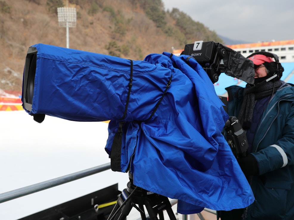 Ein Kameramann filmt beim Ski Alpin bei den Olympischen Winterspielen.