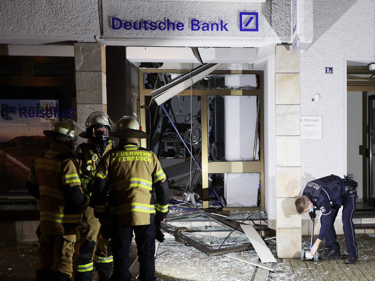 Feuerwehrleute stehen vor dem Selbstbedienungscenter der Deutschen Bank in Osterrath, in dem unbekannte Täter am 28. Dezember 2021 einen Geldautomaten gesprengt hatten.