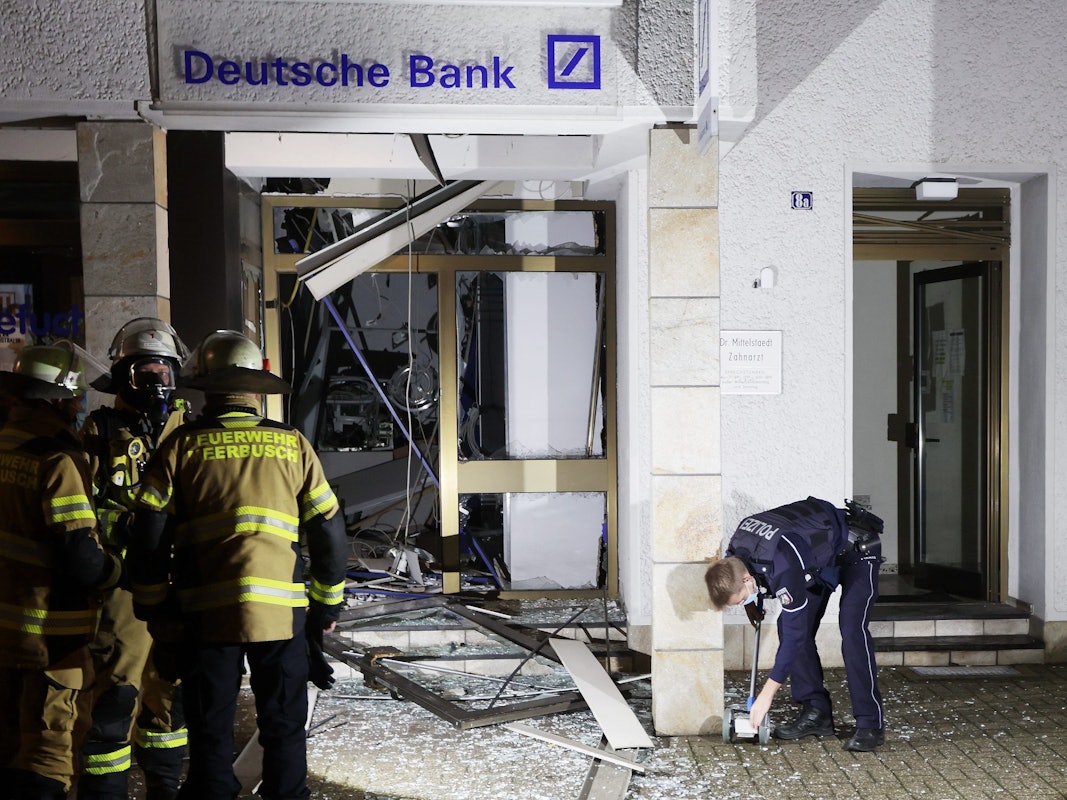 Feuerwehrleute stehen vor dem Selbstbedienungscenter der Deutschen Bank in Osterrath, in dem unbekannte Täter am 28. Dezember 2021 einen Geldautomaten gesprengt hatten.