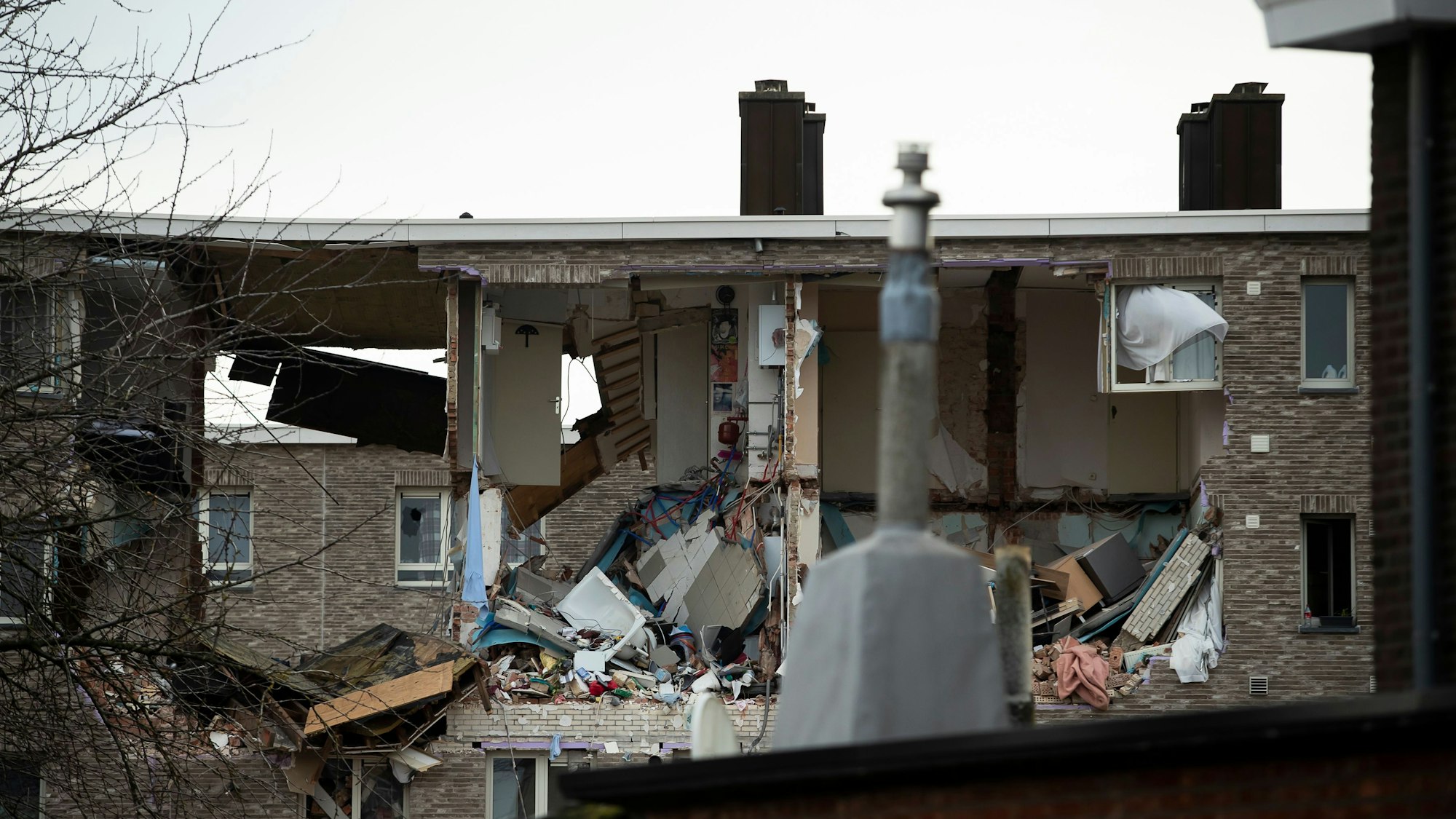 Die Gebäuderückseite eines mehrgeschossigen Mehrfamilienhauses ist durch eine Explosion schwer beschädigt.