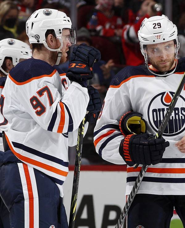 Leon Draisaitl und Connor McDavid unterhalten sich auf dem Eis.