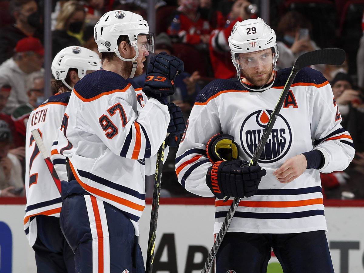 Leon Draisaitl und Connor McDavid unterhalten sich auf dem Eis.