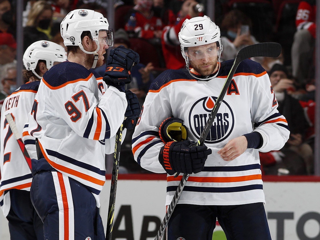 Leon Draisaitl und Connor McDavid unterhalten sich auf dem Eis.