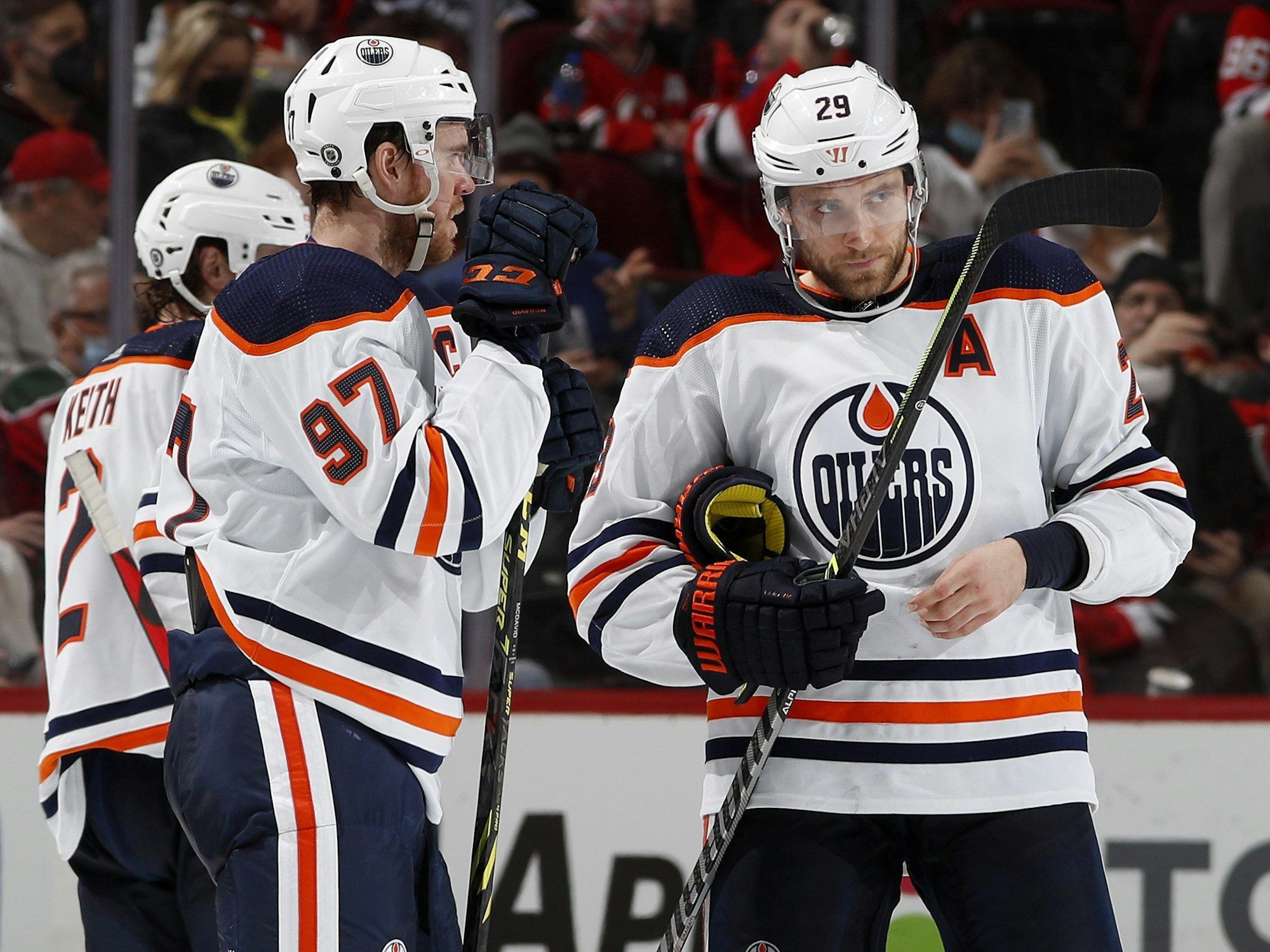 Leon Draisaitl und Connor McDavid unterhalten sich auf dem Eis.