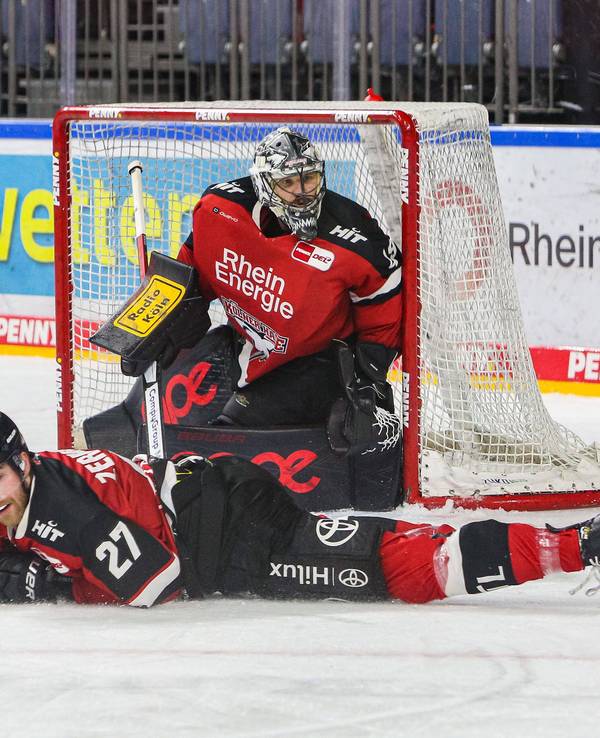 Pascal Zerressen liegt auf dem Eis, dahinter steht Justin Pogge im Tor