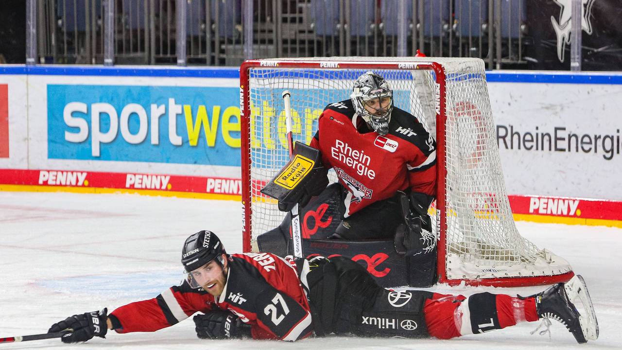 Pascal Zerressen liegt auf dem Eis, dahinter steht Justin Pogge im Tor