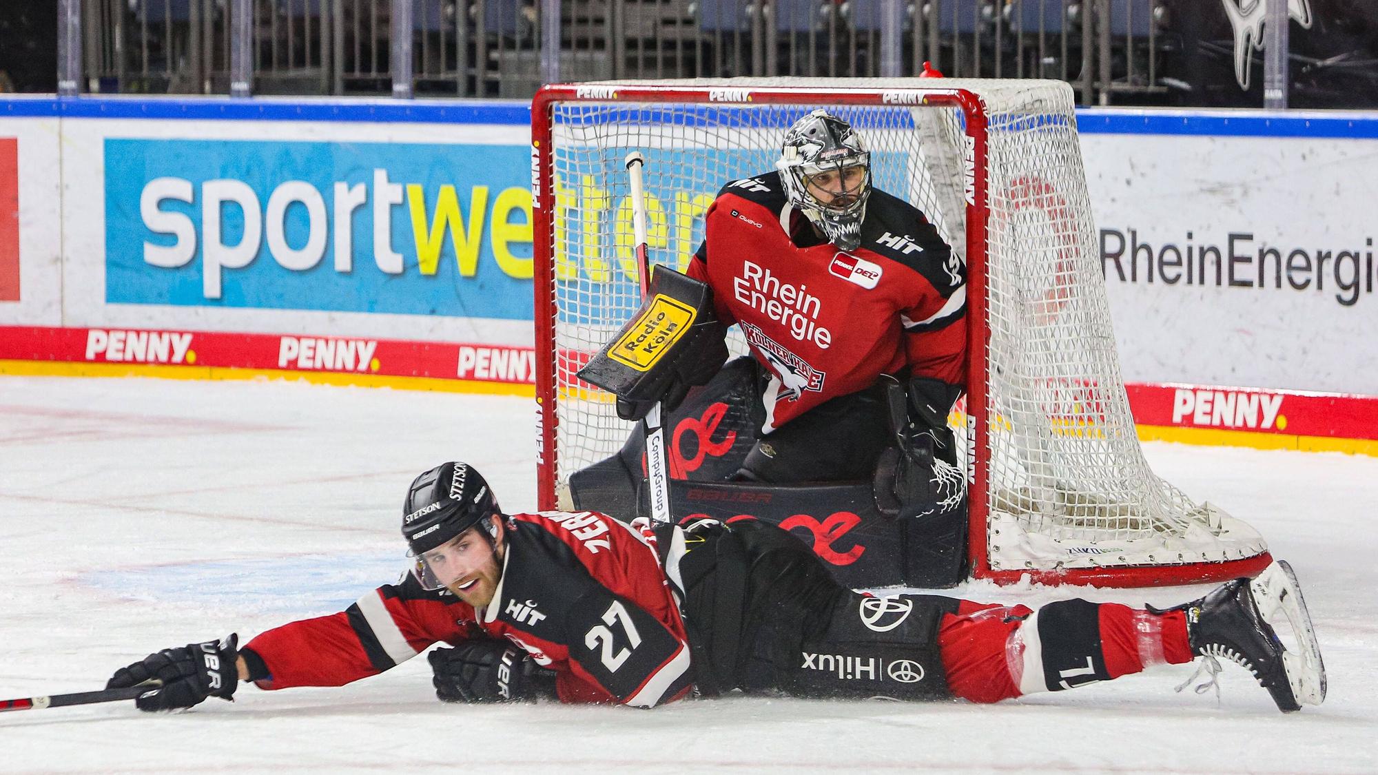 Pascal Zerressen liegt auf dem Eis, dahinter steht Justin Pogge im Tor