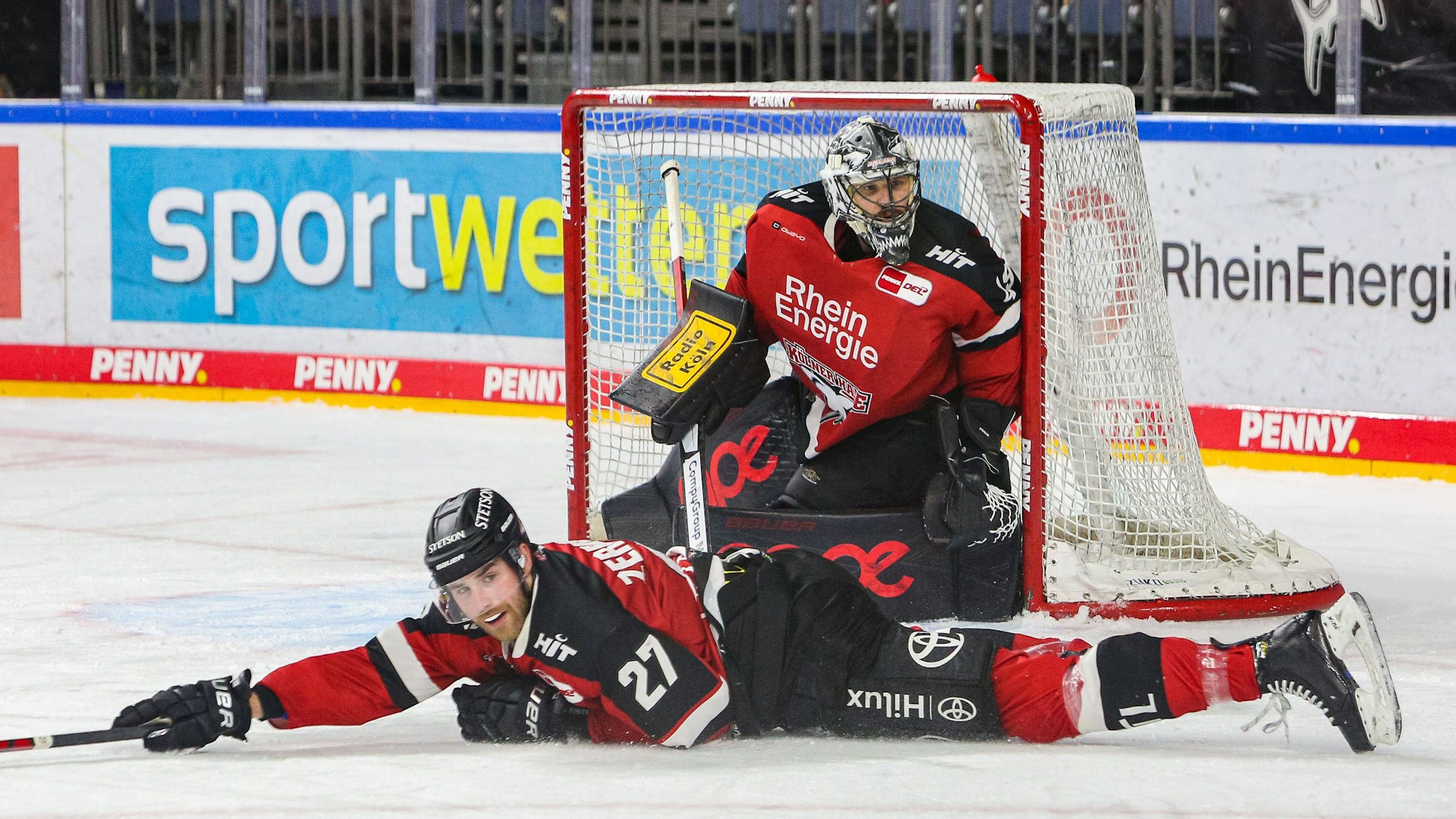 Pascal Zerressen liegt auf dem Eis, dahinter steht Justin Pogge im Tor
