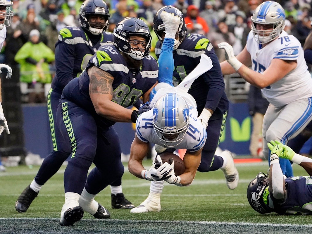 Amon-Ra St. Brown springt mit dem Football im Arm über die Touchdown-Linie.