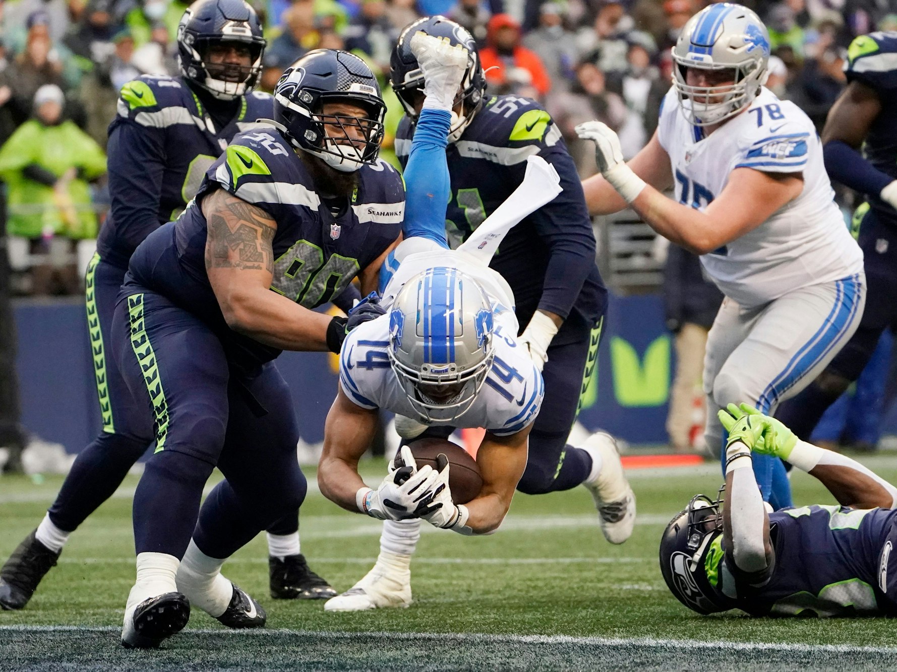 Amon-Ra St. Brown springt mit dem Football im Arm über die Touchdown-Linie.