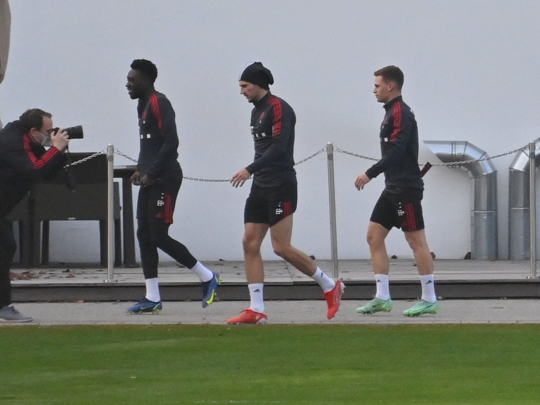 Die Bayern-Spieler Alphonso Davies, Leon Goretzka und Joshua Kimmich gehen zum Training.