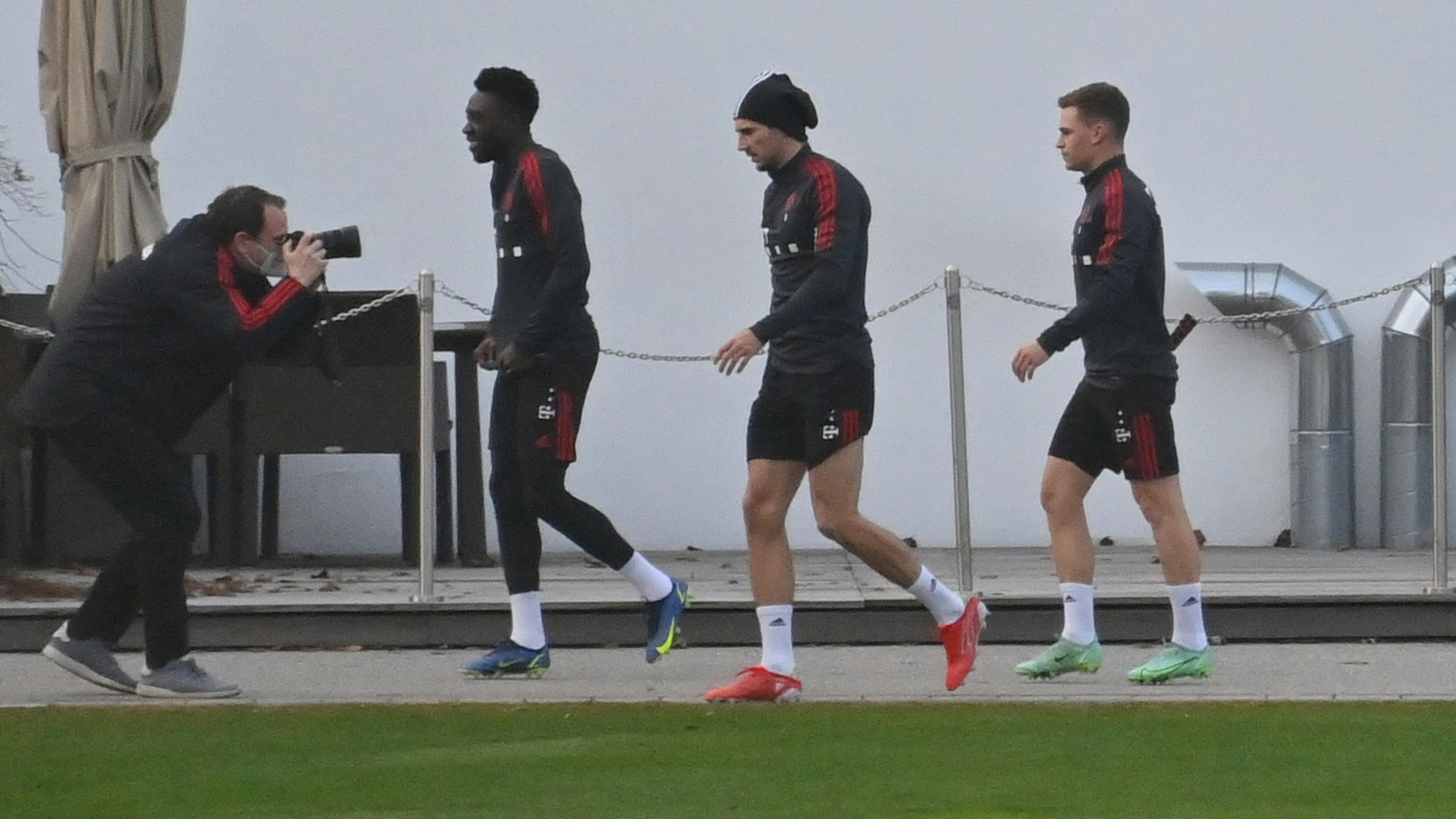 Die Bayern-Spieler Alphonso Davies, Leon Goretzka und Joshua Kimmich gehen zum Training.