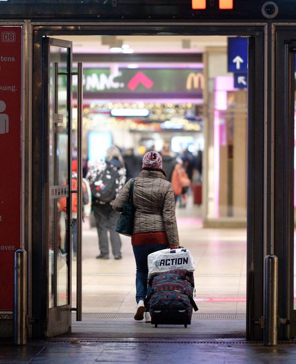 Köln: Eine Reisende geht mit einem Rollkoffer in den Hauptbahnhof.