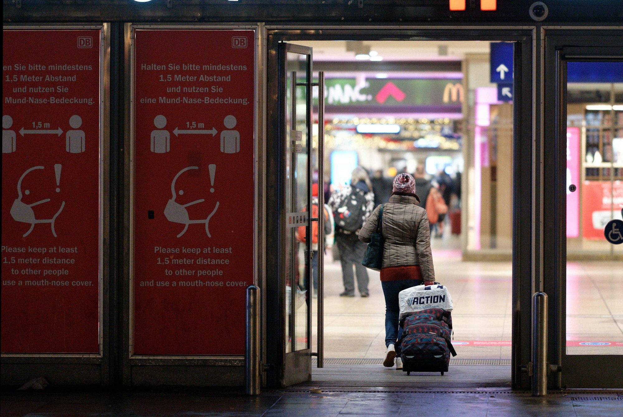 Köln: Eine Reisende geht mit einem Rollkoffer in den Hauptbahnhof.