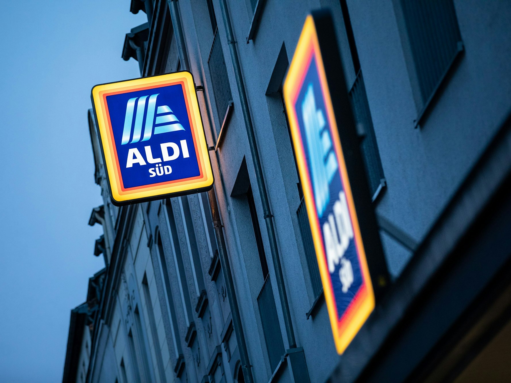 Köln: Die Leuchtreklame von Aldi Süd leuchtet am Abend über einer Filiale auf der Sülzburgstraße.