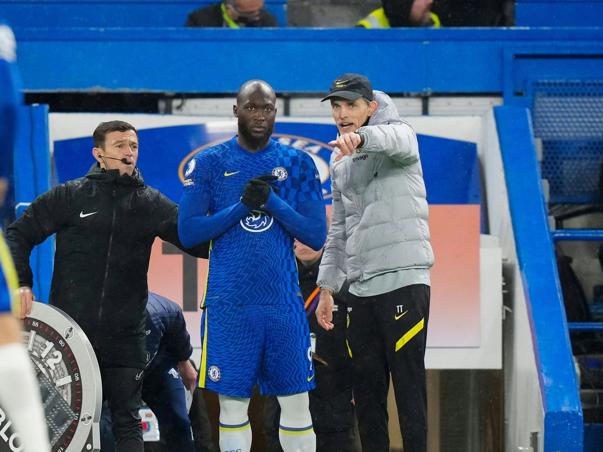 Thomas Tuchel und Lukaku stehen am Spielfeldrand, Tuchel gibt Anweisungen.