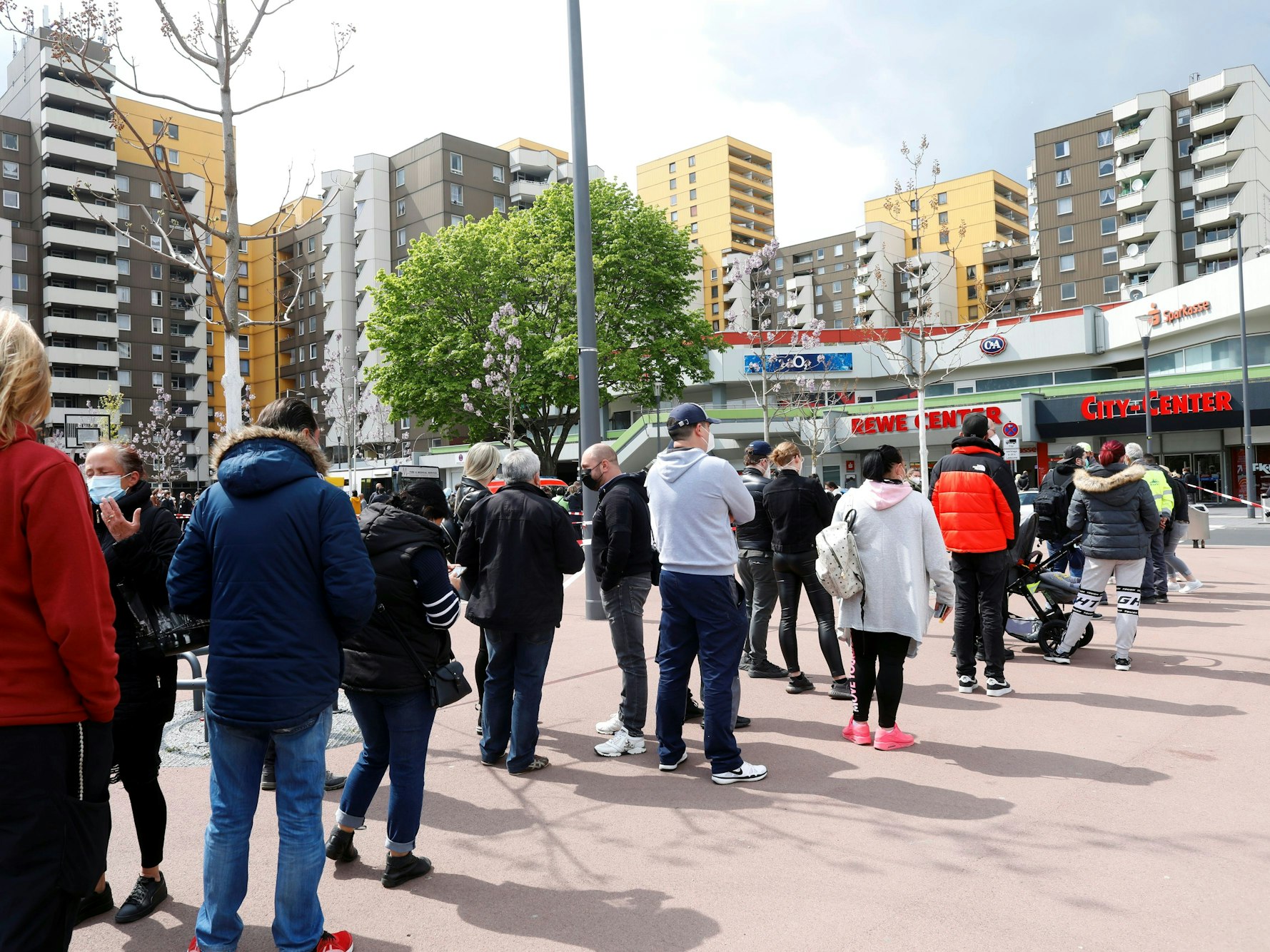 Menschen stehen Schlange vor einem Impfbus in Köln.