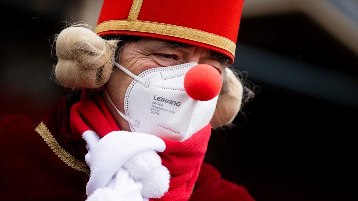 Köln: Ein Jeck mit Maske und Verkleidung steht am Severinstor, wo normalerweise der Rosenmontagszug startet.