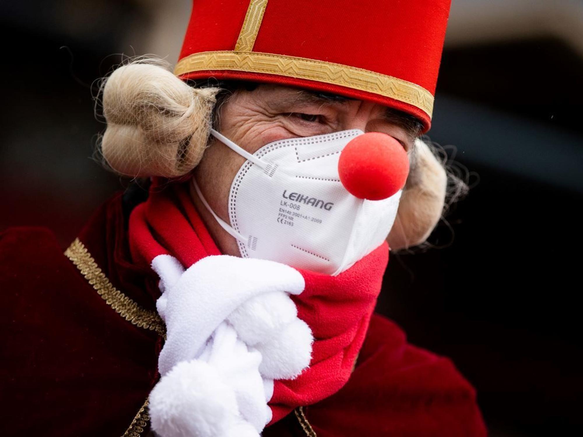 Köln: Ein Jeck mit Maske und Verkleidung steht am Severinstor, wo normalerweise der Rosenmontagszug startet.