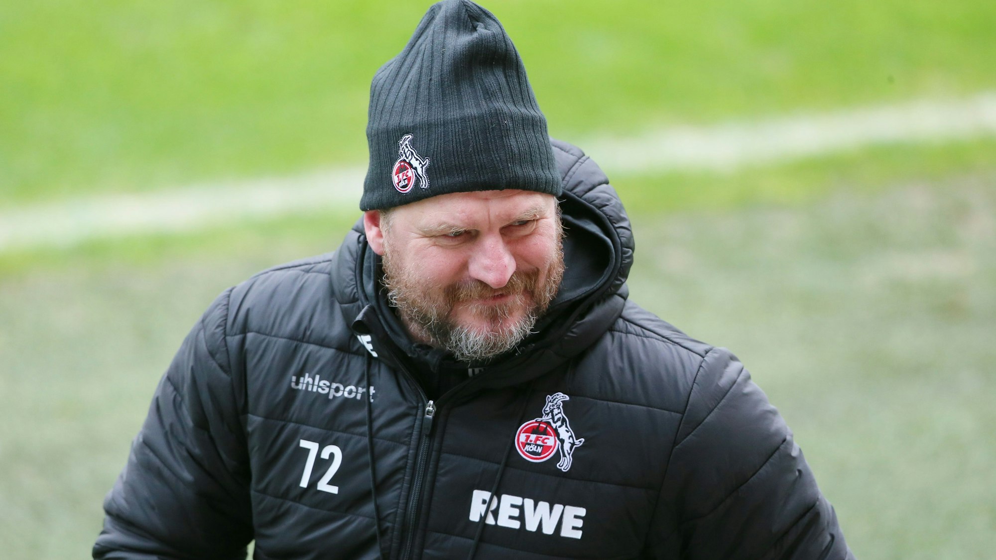 Steffen Baumgart geht lächelnd vom Trainingsplatz.