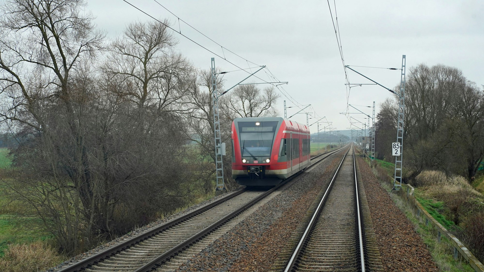 Auf dem Foto sieht man einen Zug der Deutschen Bahn, der eine Strecke abfährt.