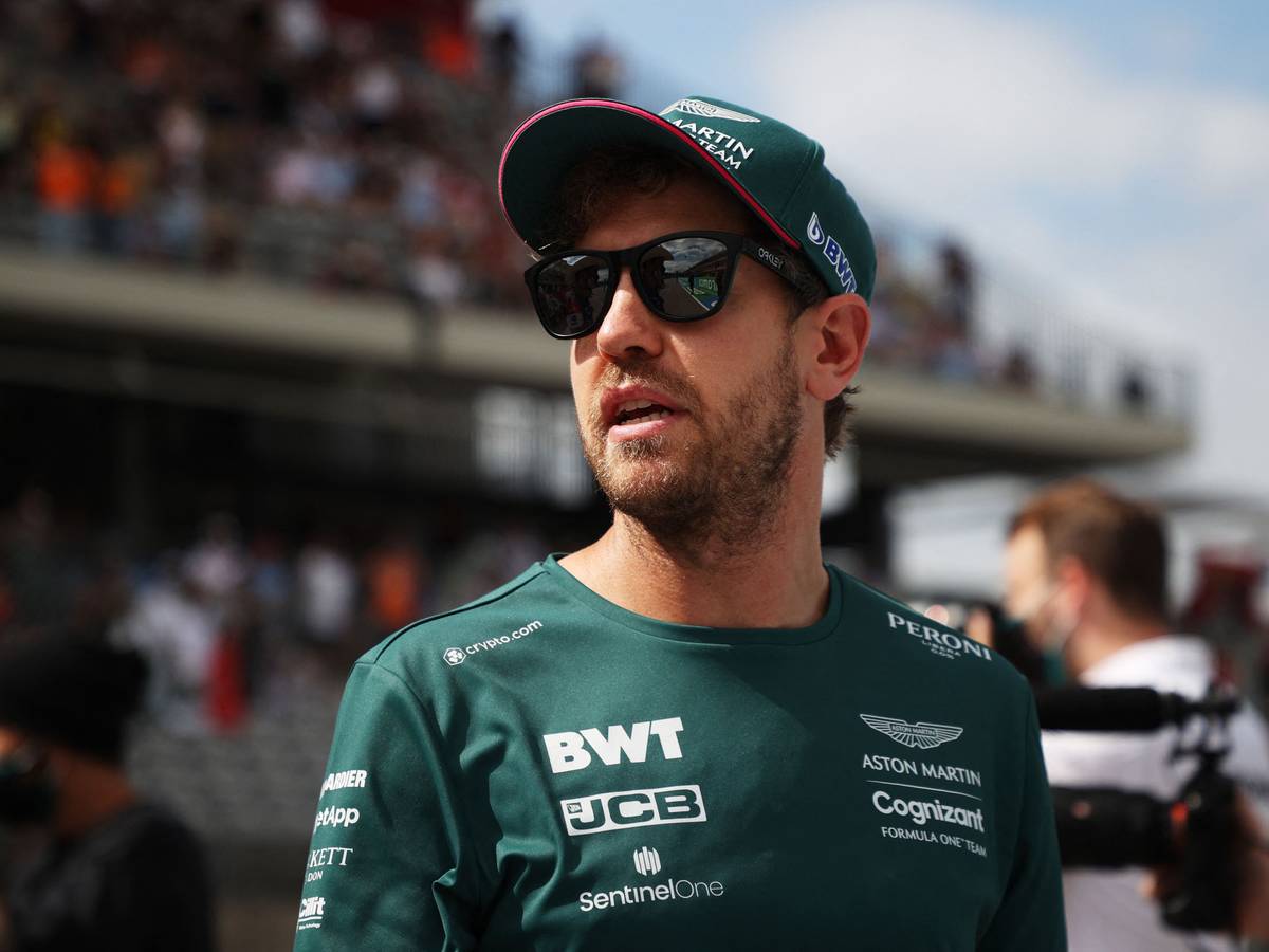 Sebastian Vettel steht mit Sonnenbrille im Fahrerlager der Formel 1.