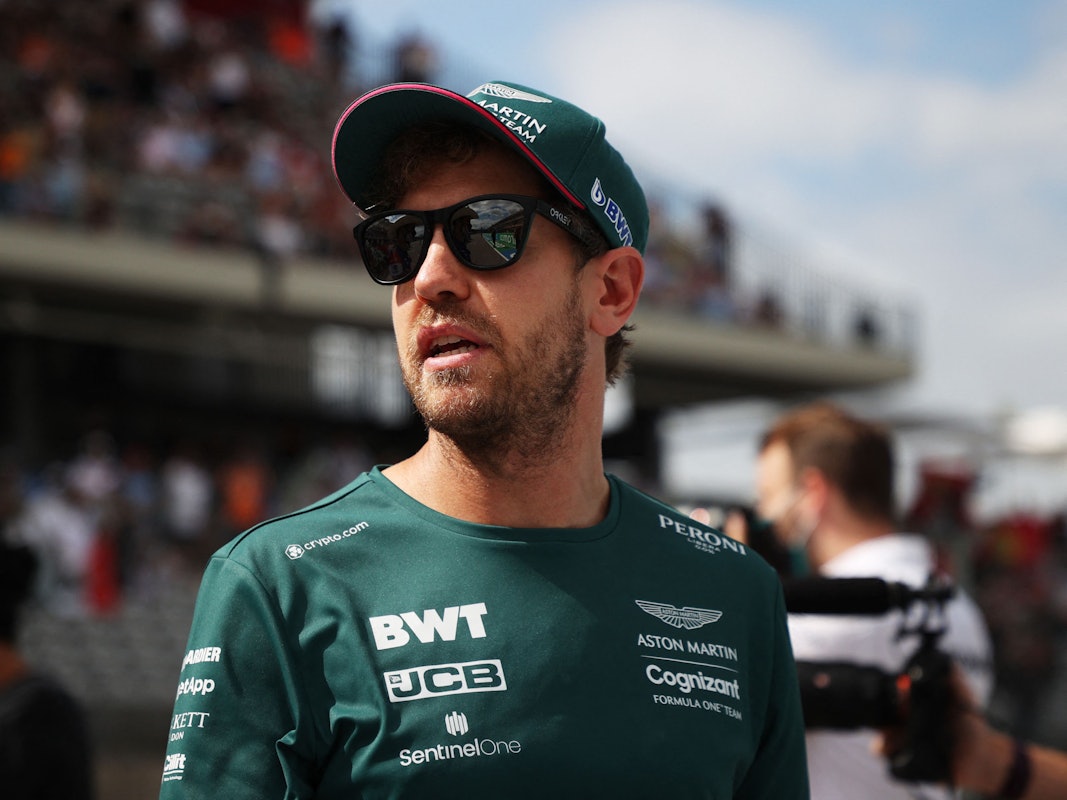 Sebastian Vettel steht mit Sonnenbrille im Fahrerlager der Formel 1.