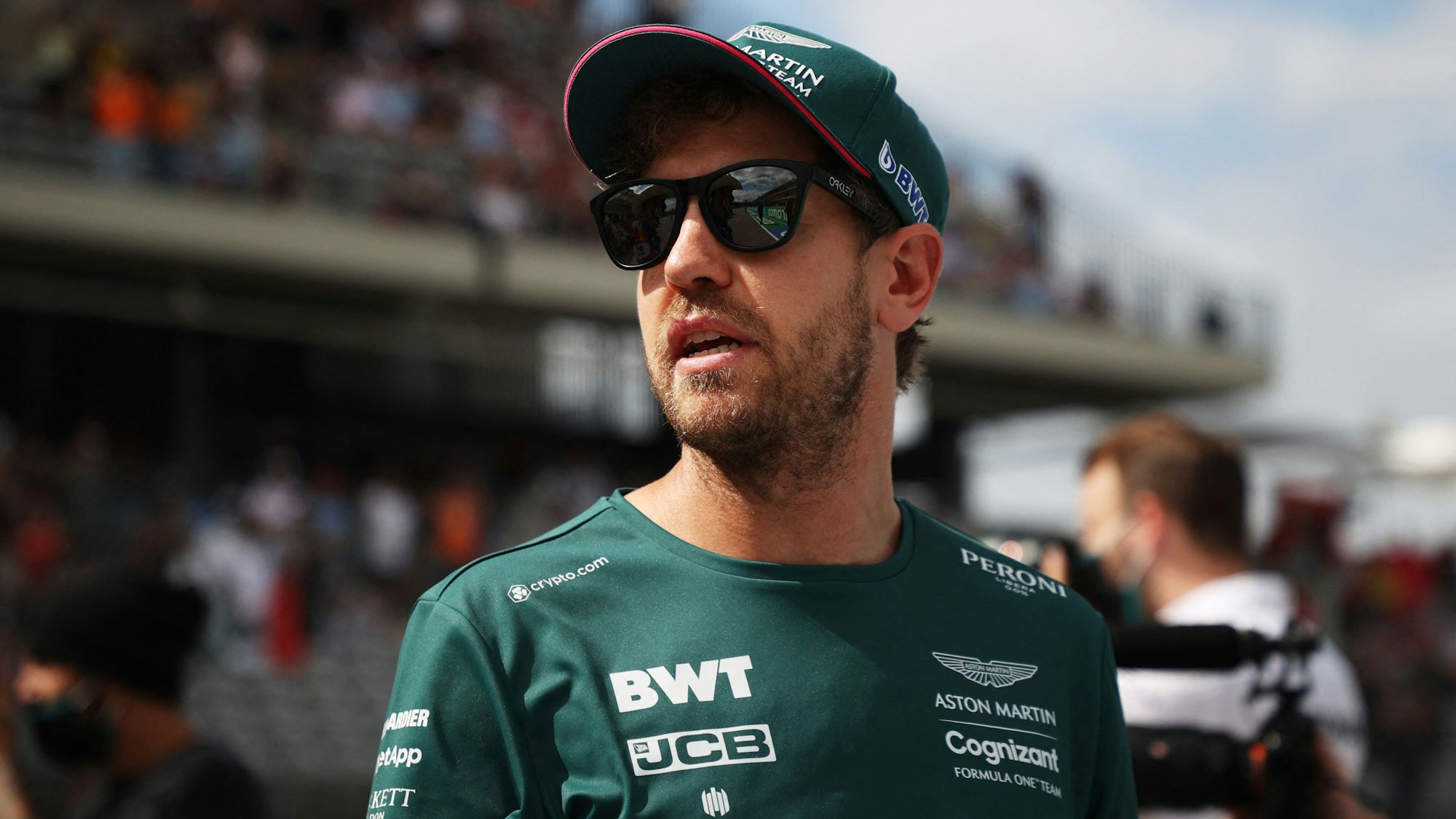 Sebastian Vettel steht mit Sonnenbrille im Fahrerlager der Formel 1.