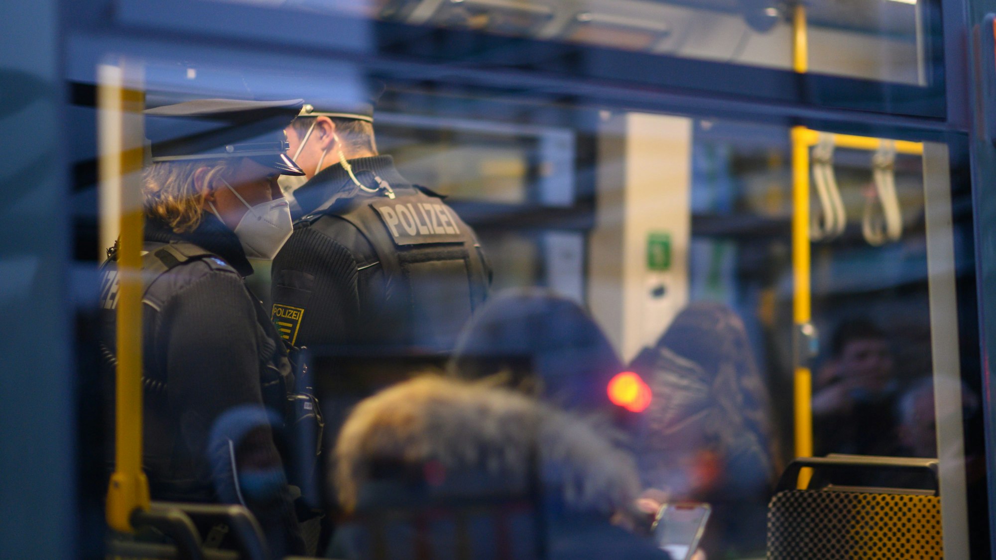 Polizisten fahren Ende November in der Dresdner Innenstadt in einer Straßenbahn mit. Je höher die Corona-Infektionszahlen steigen, desto schwieriger wird es auch, wichtige Versorgungsbereiche personell zu besetzen.