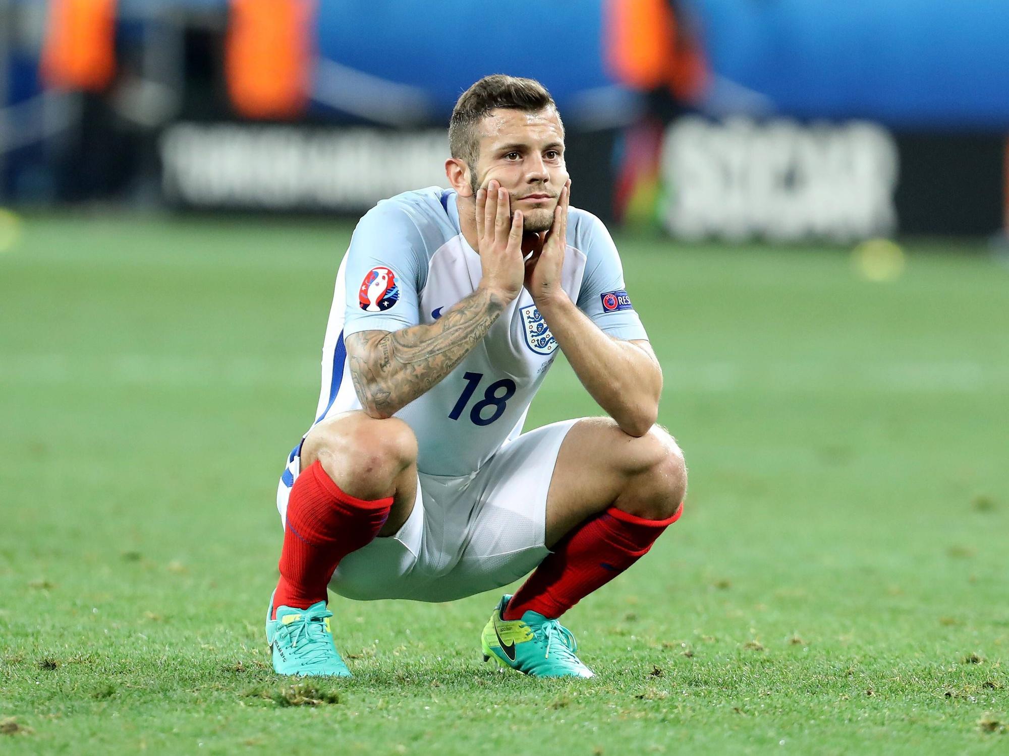 Jack Wilshere ist in der Hocke und hält mit den Händen seinen Kopf.
