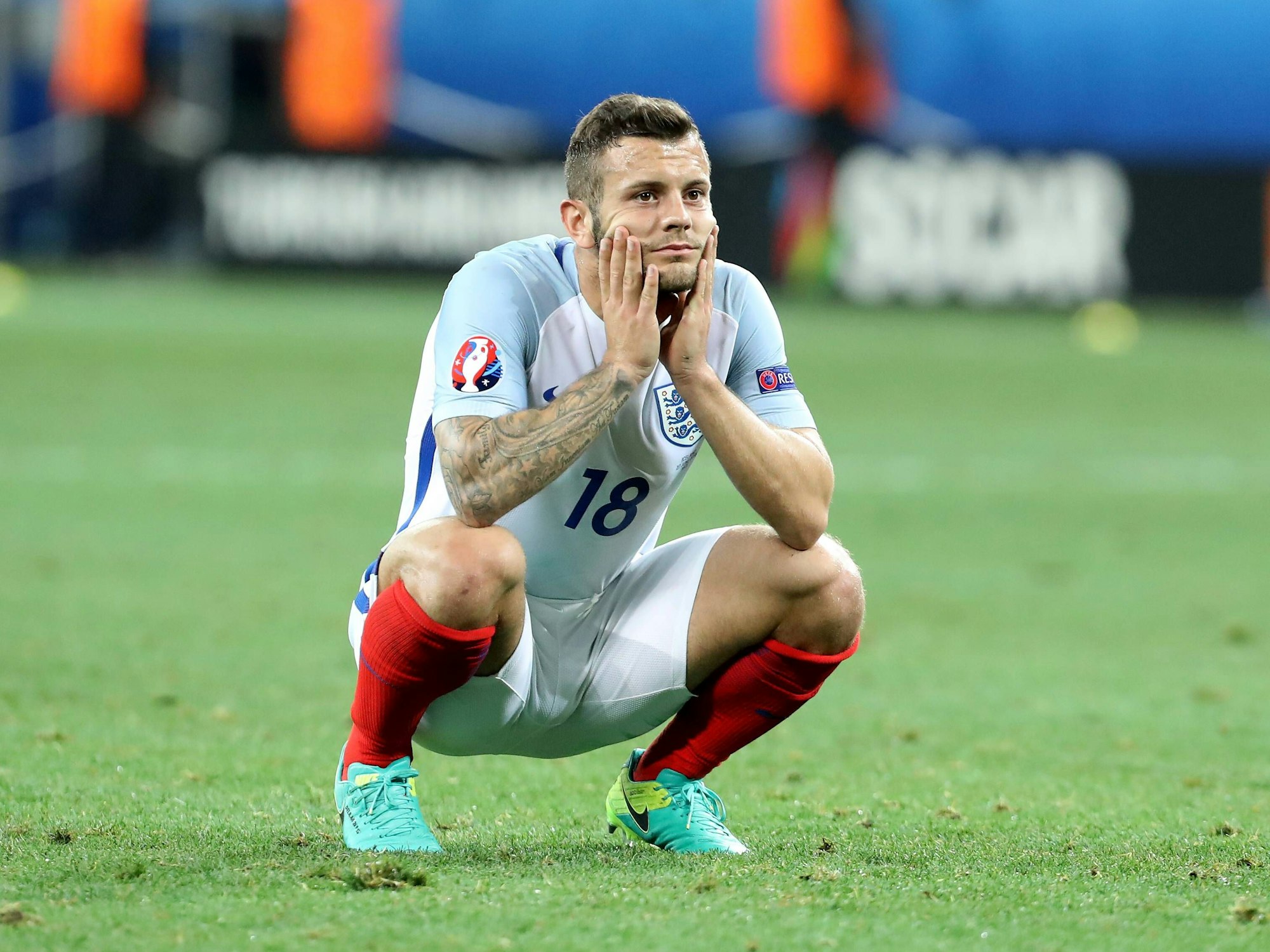 Jack Wilshere ist in der Hocke und hält mit den Händen seinen Kopf.
