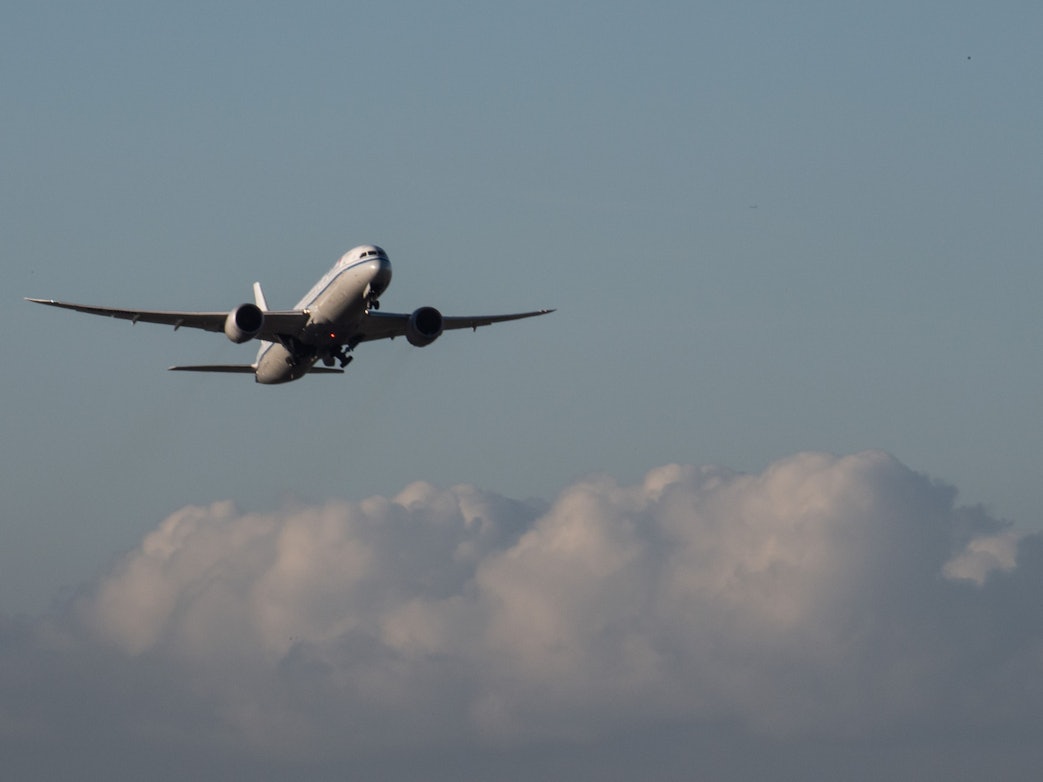 Eine Passagiermaschine fliegt über den Wolken durch den Himmel.