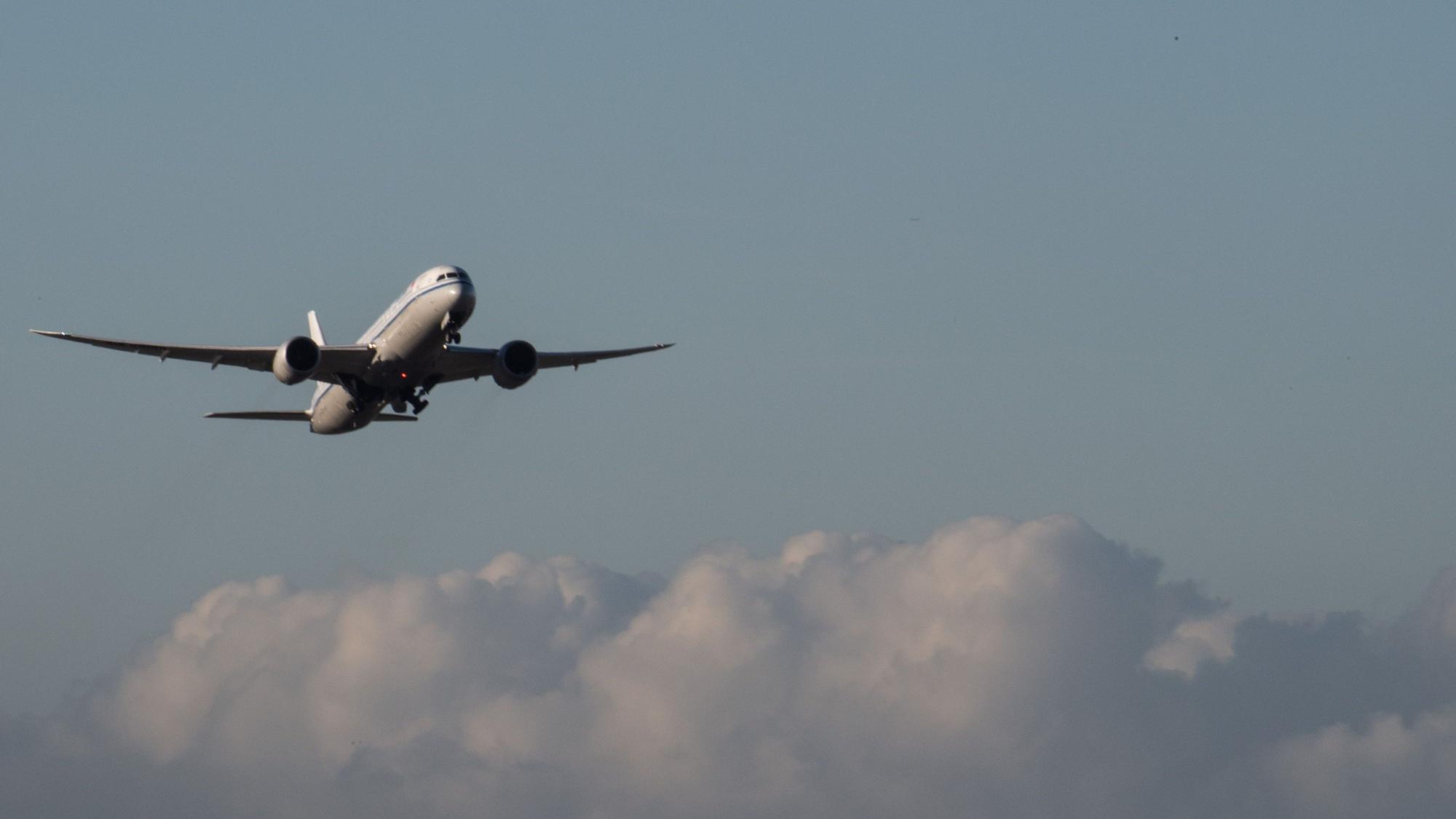 Eine Passagiermaschine fliegt über den Wolken durch den Himmel.