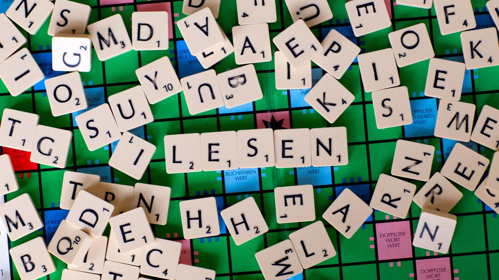 Zu sehen ist ein Scrabble-Spiel. In der Mitte des Bildes wurde der Schriftzug „Lesen“ geformt.