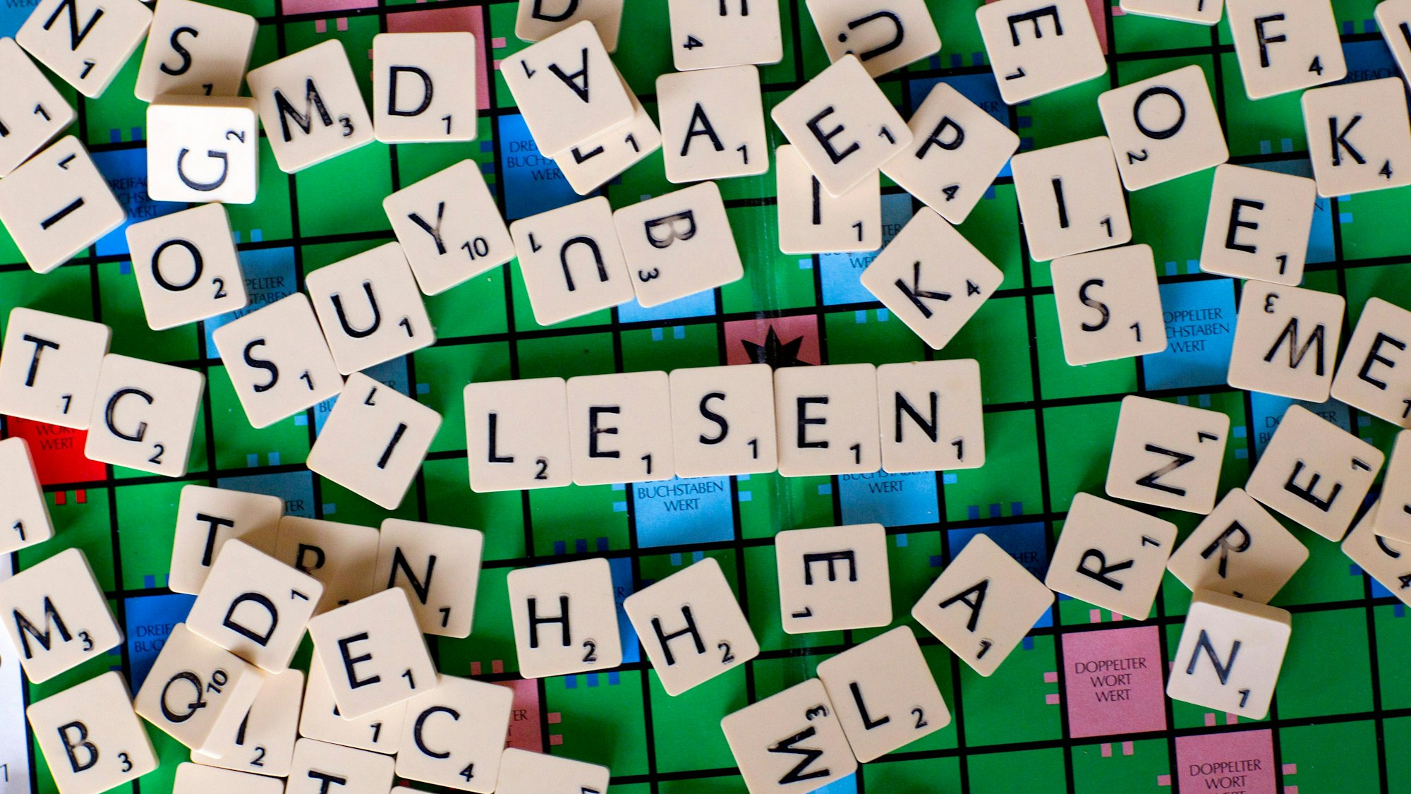 Zu sehen ist ein Scrabble-Spiel. In der Mitte des Bildes wurde der Schriftzug „Lesen“ geformt.