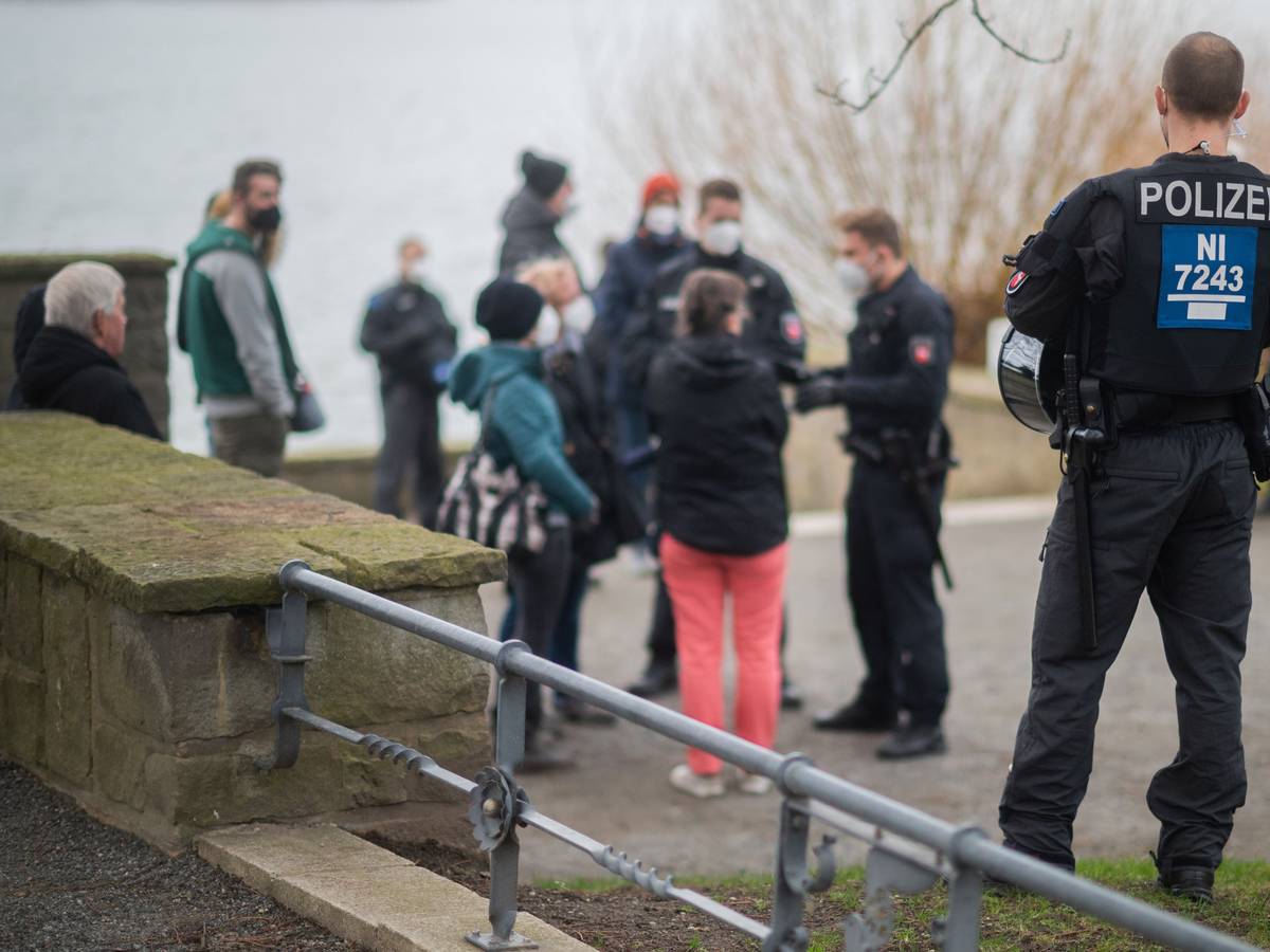 Polizisten stehen vor einer Menschengruppe an der Löwenbastion am Maschsee. Die Polizei Hannover hat einen sogenannten „Corona-Spaziergang“ - eine unangemeldete Veranstaltung mit mehreren Personen als Protest gegen die staatlichen Corona-Maßnahmen - kurzerhand als unangemeldete Demonstration bewertet. Das Symbolbild wurde am zweiten Januar 2022 aufgenommen.