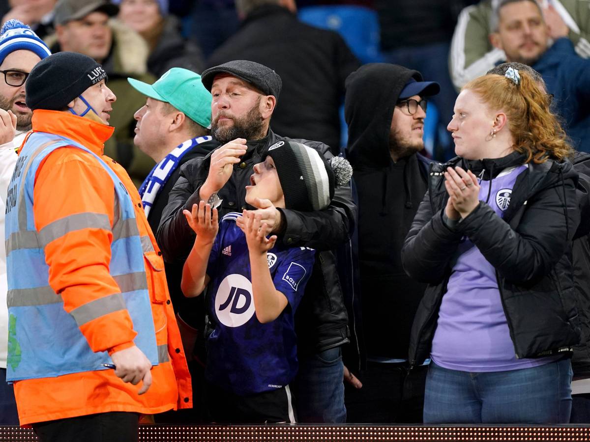 Ein Ordner spricht beim Spiel von Leeds United mit einem kleinen Flitzer und dessen Vater.