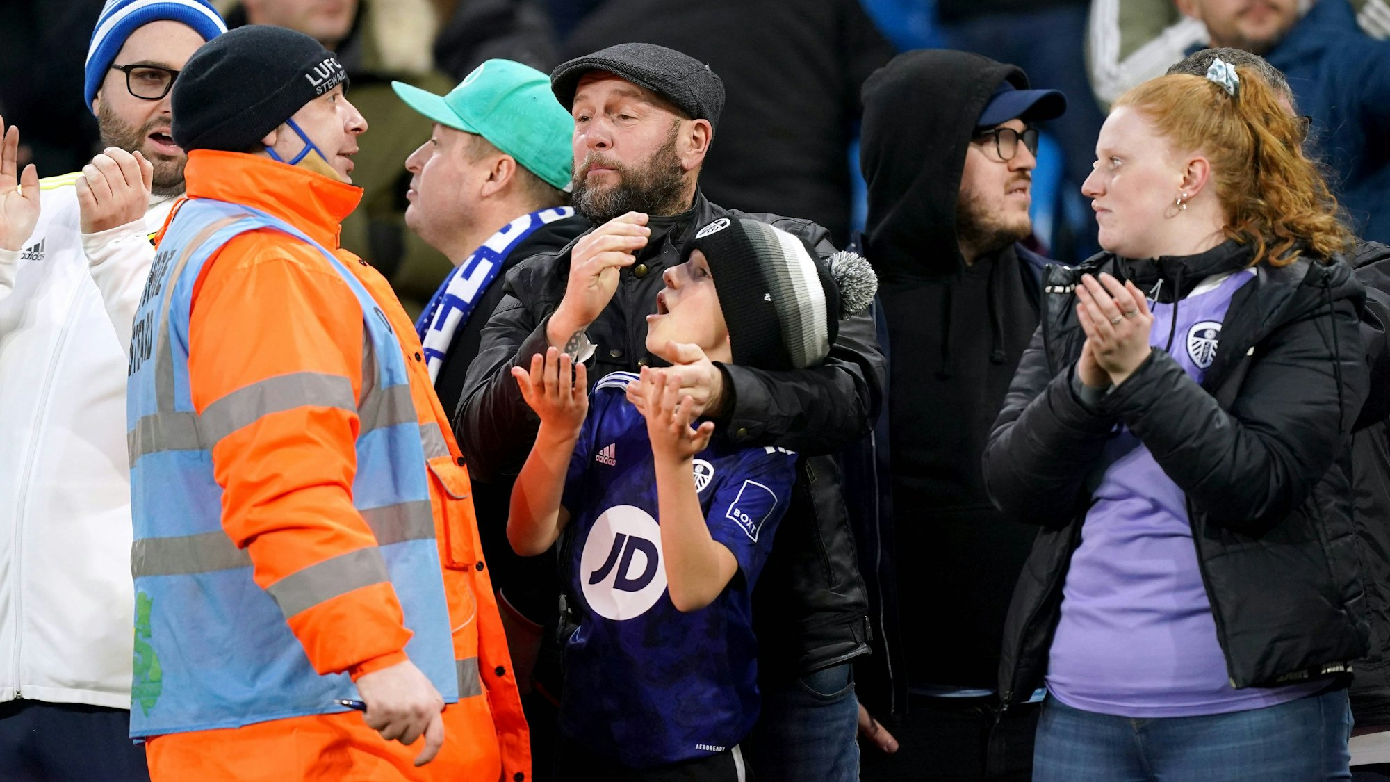Ein Ordner spricht beim Spiel von Leeds United mit einem kleinen Flitzer und dessen Vater.